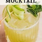 Glass of a Cucumber Lime Mocktail garnished with fresh mint and cucumber ribbons. Text overlay reads: Cucumber Lime Mocktail
