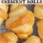 Freshly baked homemade crescent rolls cooling on a wire rack. Text overlay reads “Homemade Crescent Rolls.”