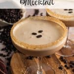 Espresso martini mocktail served in a coupe glass with a raw sugar rim, topped with three coffee beans on a creamy frothy layer, surrounded by scattered coffee beans on a wooden board. Text overlay reads: Espresso Martini Mocktail.
