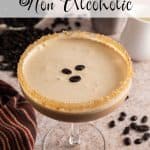 Espresso martini mocktail in a coupe glass with a sugared rim and frothy top, garnished with three coffee beans. A cocktail shaker, cream pitcher, and scattered coffee beans are in the background. Text overlay reads: Espresso martini Non Alcoholic.
