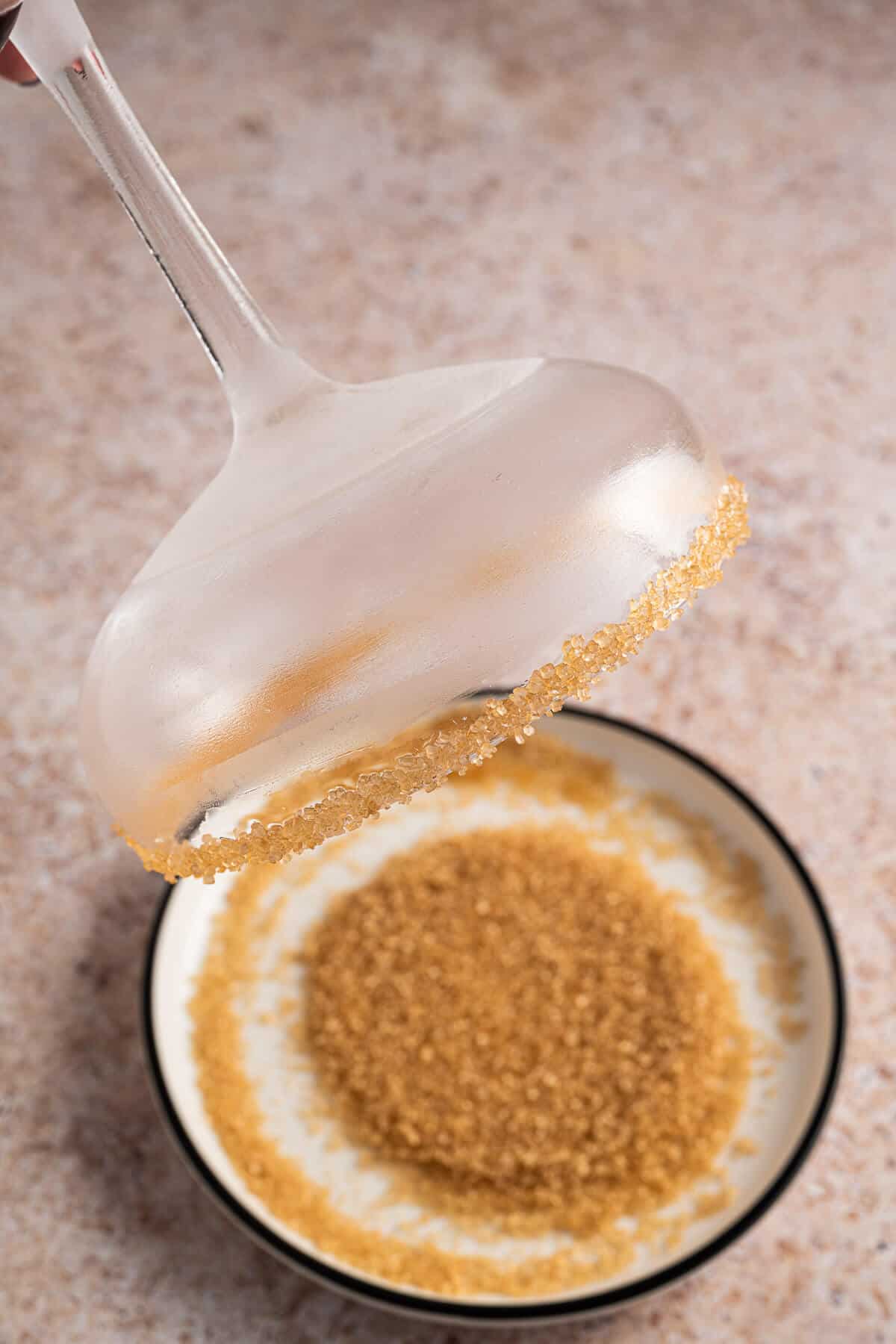 Coupe glass just dipped into a shallow saucer of Turbinado sugar in order to rim the glass.