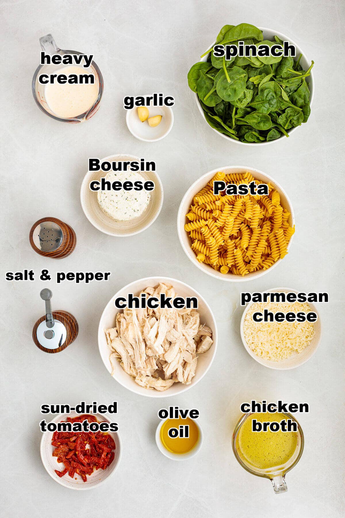 Ingredients for Boursin Chicken Pasta: heavy cream, garlic, spinach, Boursin cheese, pasta, salt, pepper, chicken, parmesan cheese, sun-dried tomates, olive oil, and chicken broth.