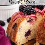 Slice of lemon blackberry bundt cake pulled away from the cake, showing moist crumb and blackberry pockets with fresh blackberries and blackberry glaze on top. Text overlay reads: Lemon Blackberry Bundt Cake.